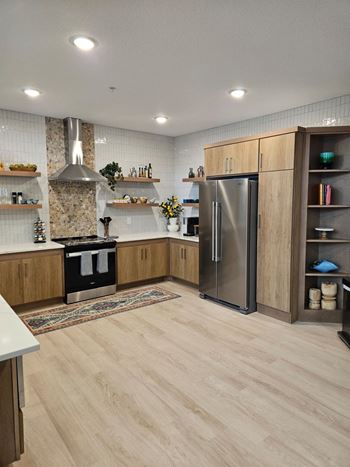 A modern kitchen with wooden cabinets and a stainless steel refrigerator.